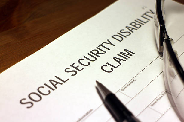 A Social Security Disability claim with a pair of glasses and a pen sitting on it