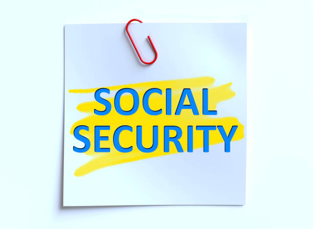 Social Security written in blue lettering on a small post-it note with a red paper clip.